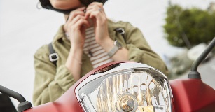 Motocicletta Indovinate le mani di una donna su una moto che attacca il casco