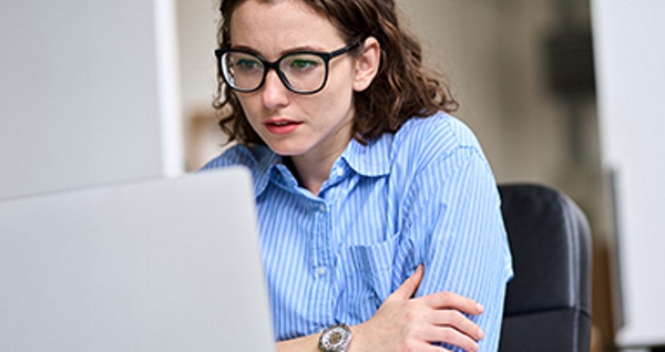 Eine Person, die konzentriert an einem Laptop arbeitet.
