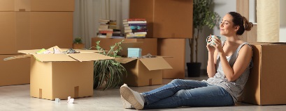 Une personne assise par terre, prenant une pause pendant un déménagement.