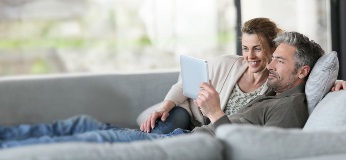 Coppia su un divano che guarda un tablet