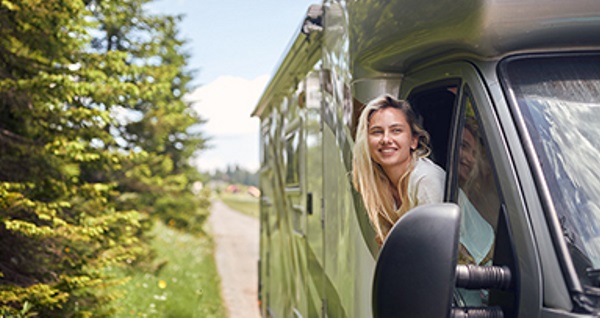 Due persone sorridenti in un camper, pronte per un viaggio.