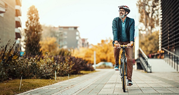 Un uomo in bicicletta che si sposta in città.