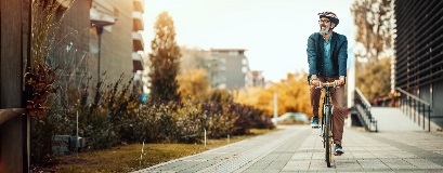 Un uomo in bicicletta che si sposta in città.