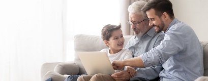 Trois générations de famille regardant ensemble un ordinateur portable.