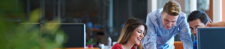 Due colleghi o partner commerciali che discutono attorno a un computer portatile.