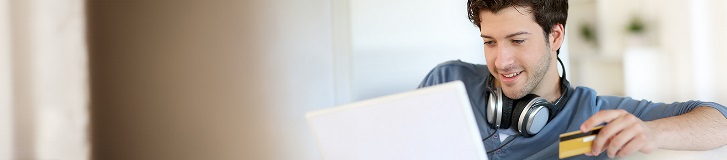 Un giovane uomo che fa acquisti online con una carta di credito.